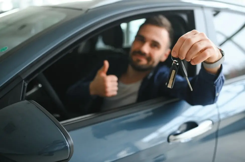 Happy customer receiving car keys from CarsRental