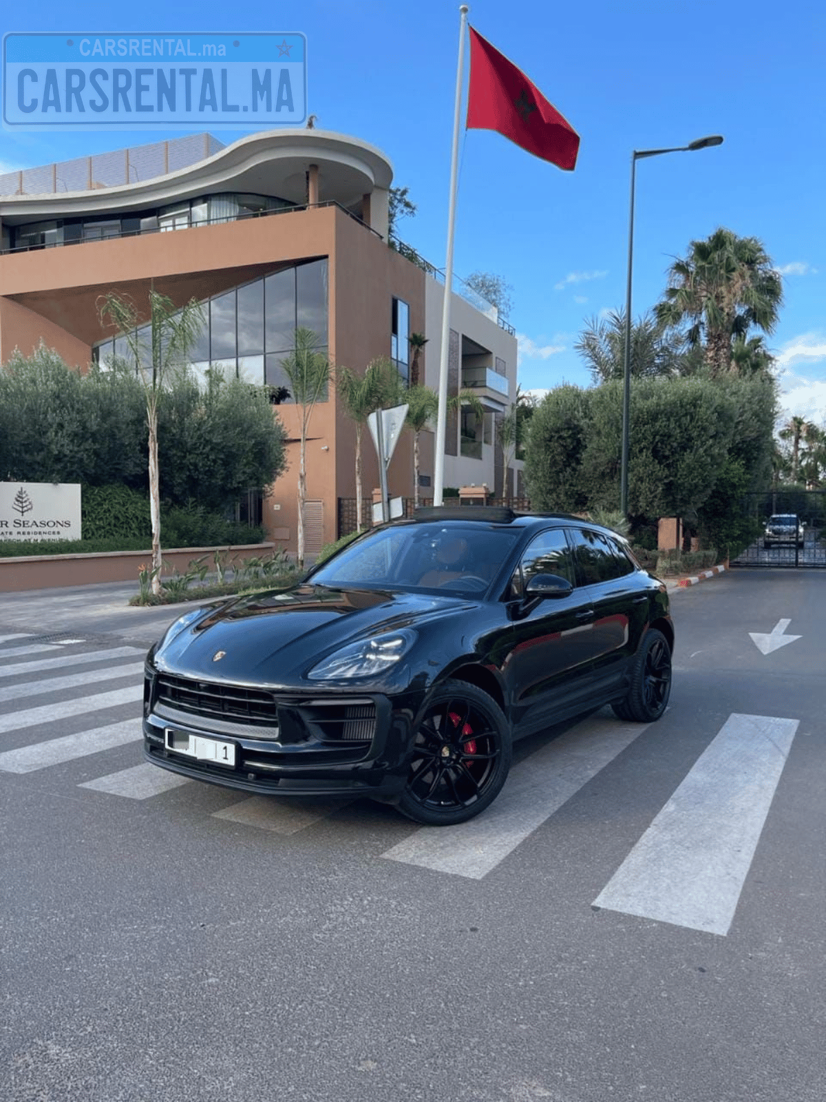 Porsche luxury rental car in front of Moroccan flag